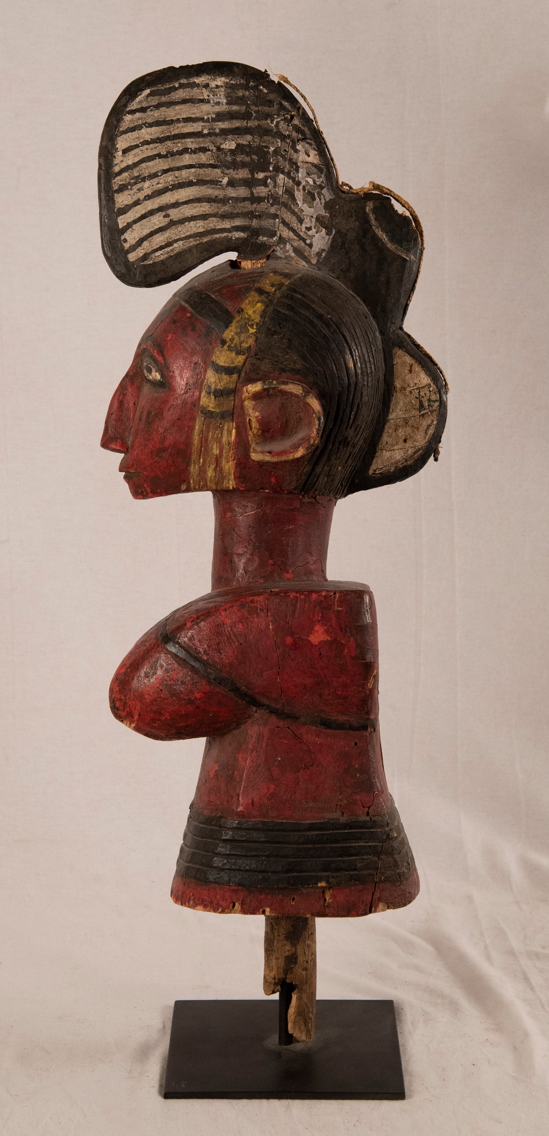 Ivory Coast Baule female ancestral figure in carved red and black polychromed wood on a metal stand