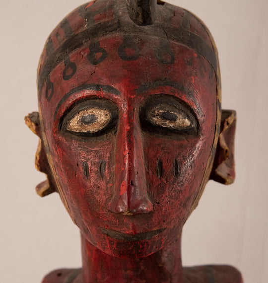Ivory Coast Baule female ancestral figure in carved red and black polychromed wood on a metal stand